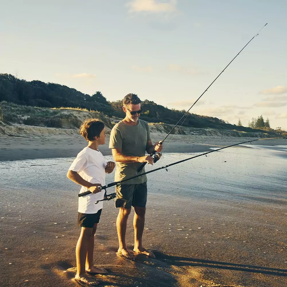 A father and son are fishing off the beach